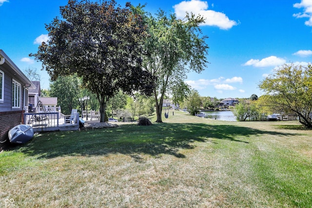 view of yard with a deck with water view