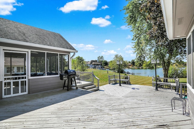 deck featuring grilling area, a sunroom, and a water view