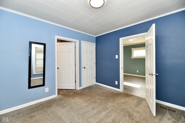 unfurnished bedroom featuring crown molding and carpet flooring