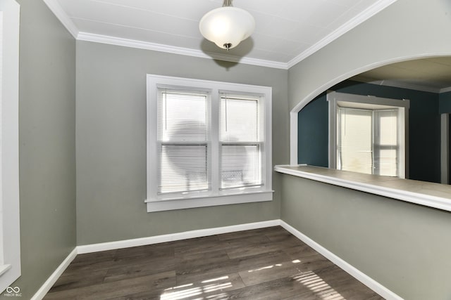 empty room featuring dark wood-type flooring and ornamental molding