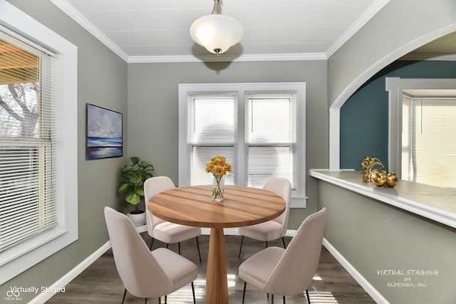 dining area featuring ornamental molding and dark hardwood / wood-style flooring