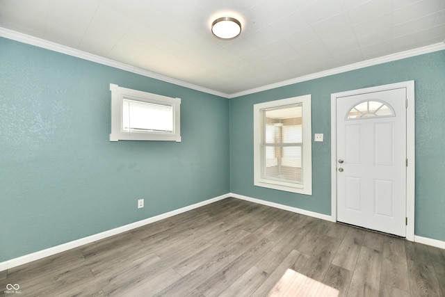 foyer entrance featuring crown molding and light wood-type flooring