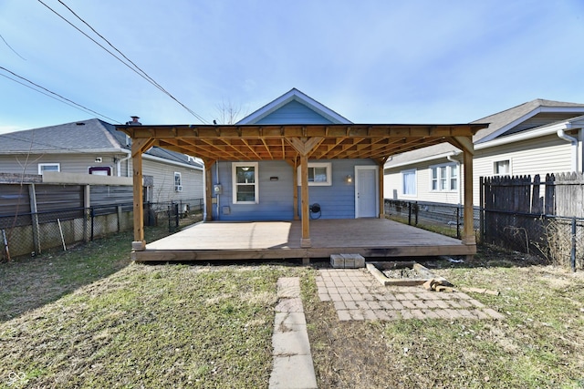 rear view of property featuring a patio area, a deck, and a lawn