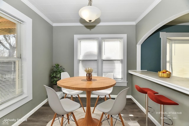 dining space featuring hardwood / wood-style flooring and crown molding