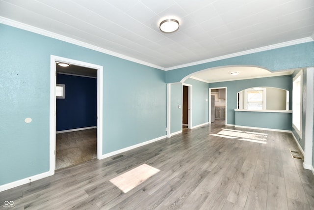 spare room with crown molding and wood-type flooring