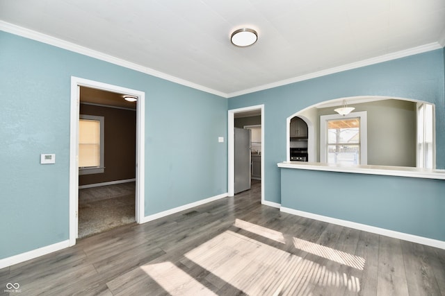 empty room featuring crown molding and dark hardwood / wood-style floors