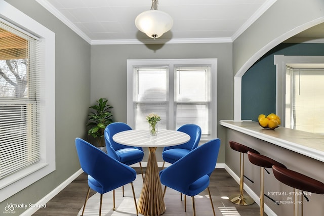 dining space featuring dark wood-type flooring and ornamental molding