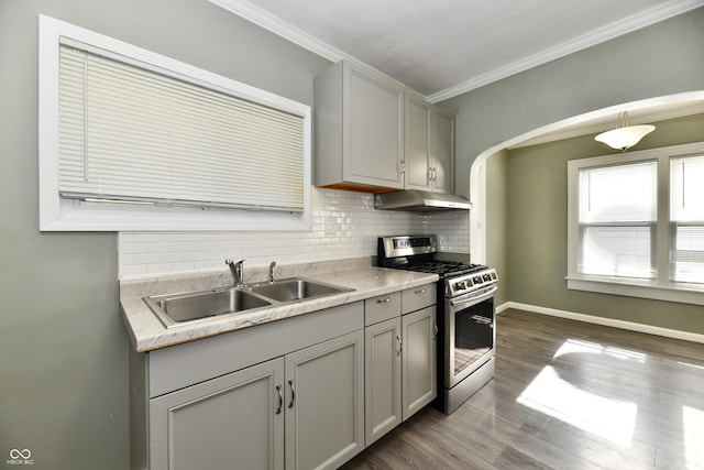 kitchen with stainless steel gas stove, sink, backsplash, and gray cabinetry