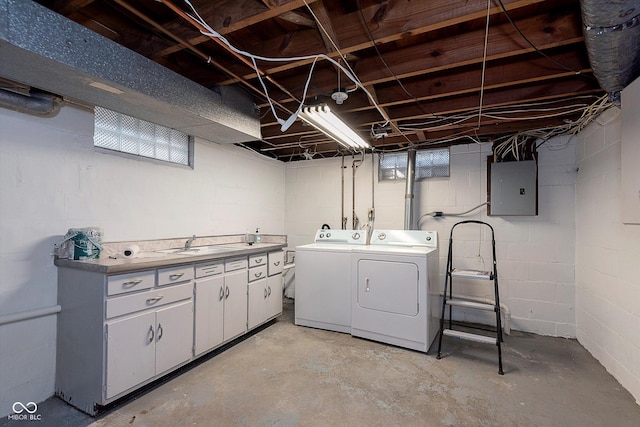 clothes washing area featuring cabinets, electric panel, sink, and washer and dryer