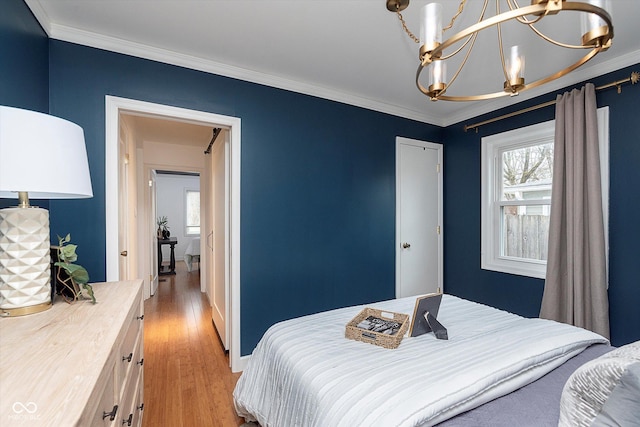 bedroom with crown molding, light hardwood / wood-style floors, and a closet