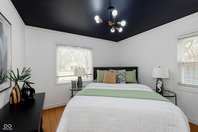 bedroom with crown molding, hardwood / wood-style floors, and a notable chandelier