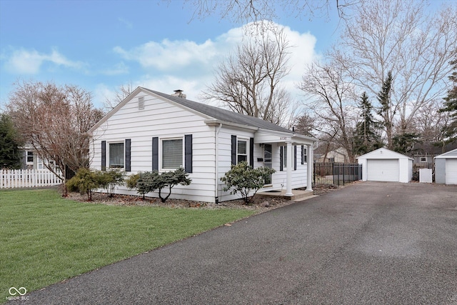 view of front of home with a garage, an outdoor structure, and a front lawn