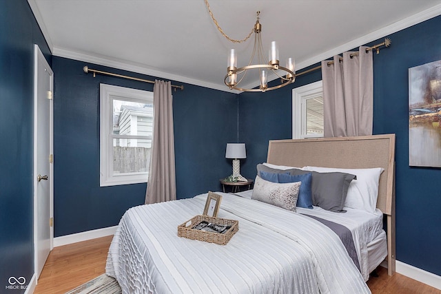 bedroom with hardwood / wood-style flooring, ornamental molding, and a notable chandelier