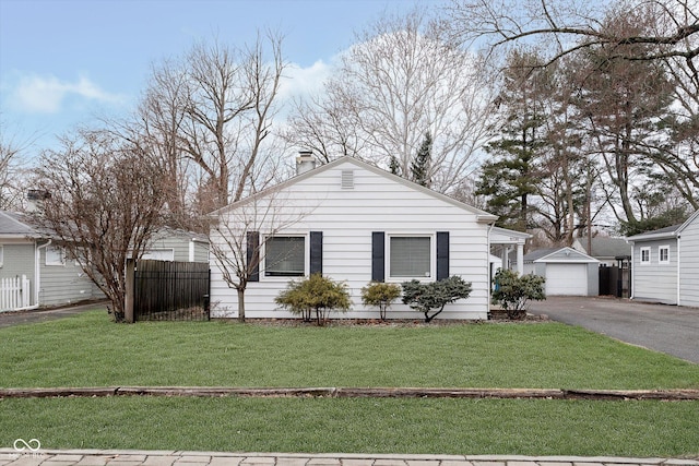 view of front of property with a garage, an outdoor structure, and a front yard