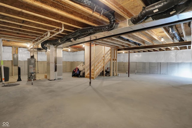 basement with heating unit, gas water heater, and electric panel