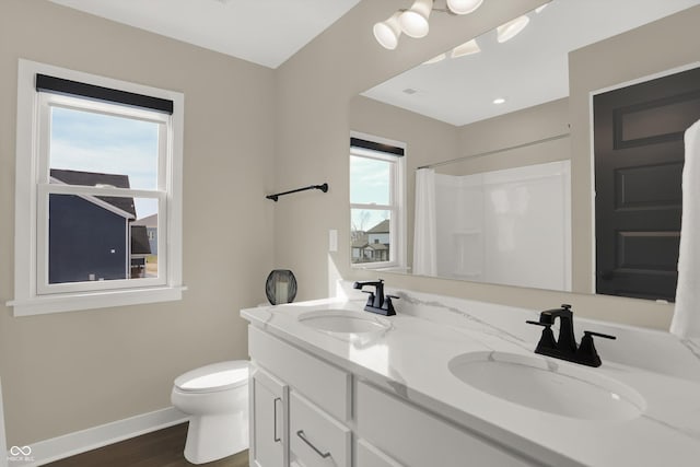 bathroom featuring vanity, hardwood / wood-style floors, toilet, and walk in shower