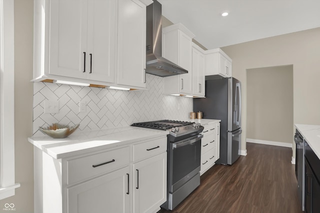 kitchen with wall chimney range hood, white cabinetry, stainless steel appliances, light stone counters, and tasteful backsplash