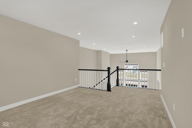 carpeted spare room featuring ceiling fan