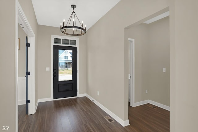 entrance foyer featuring dark hardwood / wood-style floors and an inviting chandelier