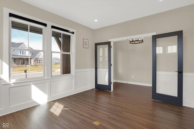 spare room with dark hardwood / wood-style floors and french doors