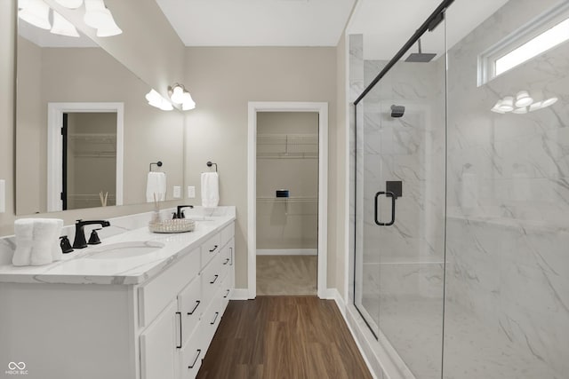 bathroom featuring wood-type flooring, an enclosed shower, and vanity