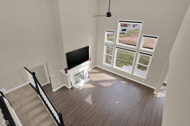 unfurnished living room featuring a high ceiling and hardwood / wood-style flooring