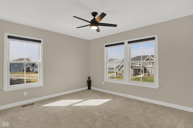 carpeted spare room featuring ceiling fan