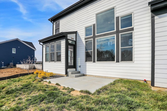 rear view of property featuring a lawn and a patio area