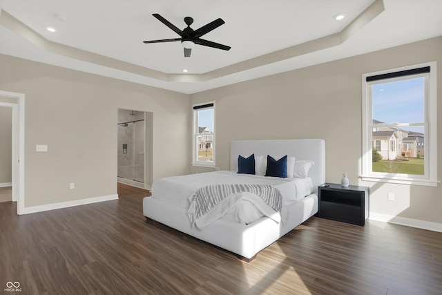 bedroom featuring a raised ceiling, dark hardwood / wood-style floors, and ceiling fan