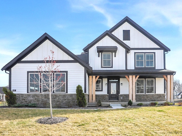 modern farmhouse featuring board and batten siding, stone siding, a porch, and a front lawn