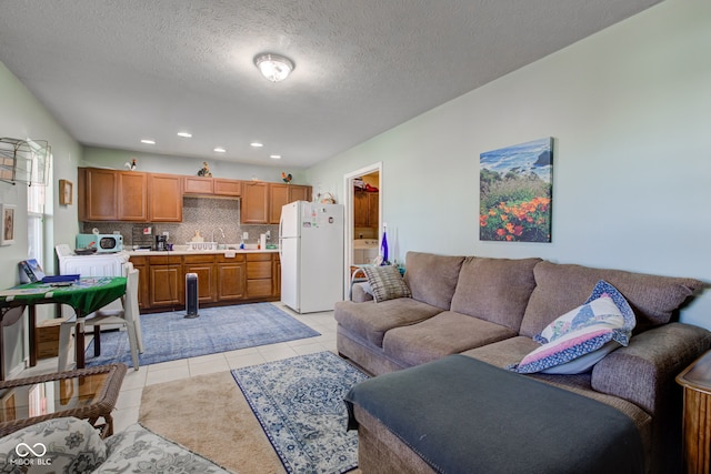 living area with light tile patterned floors, recessed lighting, and a textured ceiling