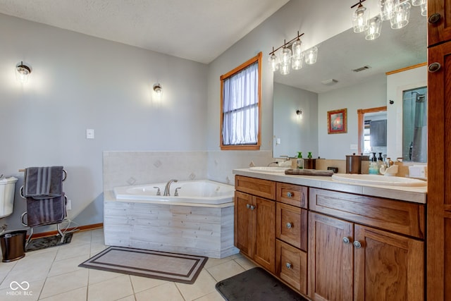 bathroom featuring visible vents, double vanity, a bath, tile patterned floors, and a sink