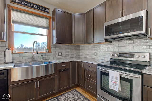 kitchen with a sink, dark brown cabinetry, and appliances with stainless steel finishes