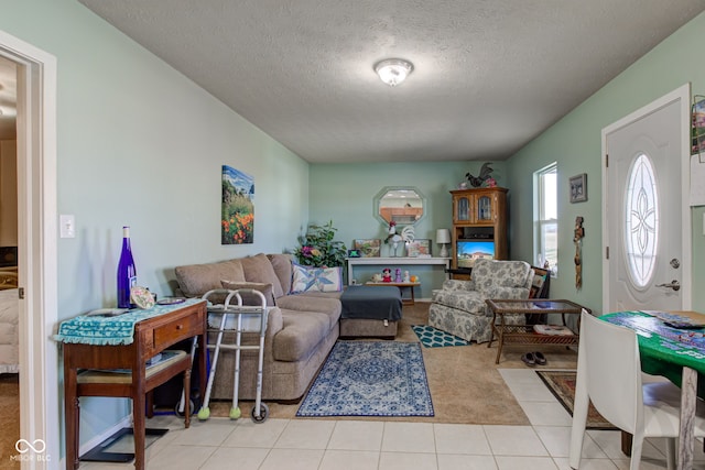 living area with light tile patterned flooring and a textured ceiling