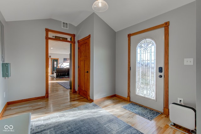 entryway with light wood finished floors, visible vents, baseboards, and lofted ceiling