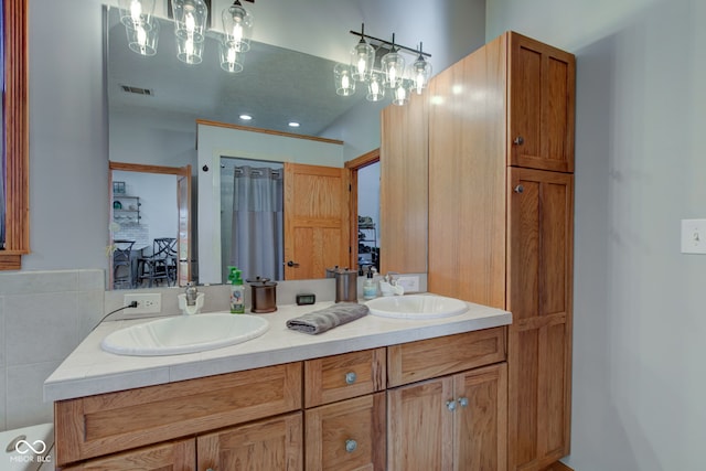 full bathroom with double vanity, visible vents, and a sink