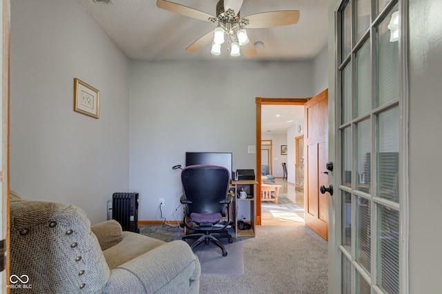 office space featuring baseboards, ceiling fan, radiator heating unit, carpet flooring, and french doors