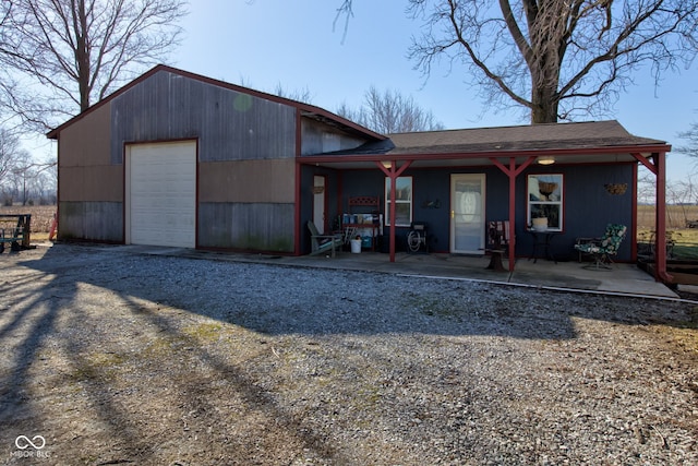 view of front of home featuring a porch, a detached garage, and driveway