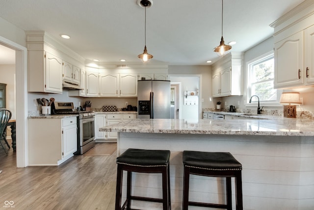 kitchen featuring white cabinetry, appliances with stainless steel finishes, sink, and light stone counters