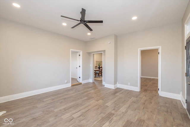 unfurnished bedroom featuring ceiling fan, a walk in closet, and light wood-type flooring