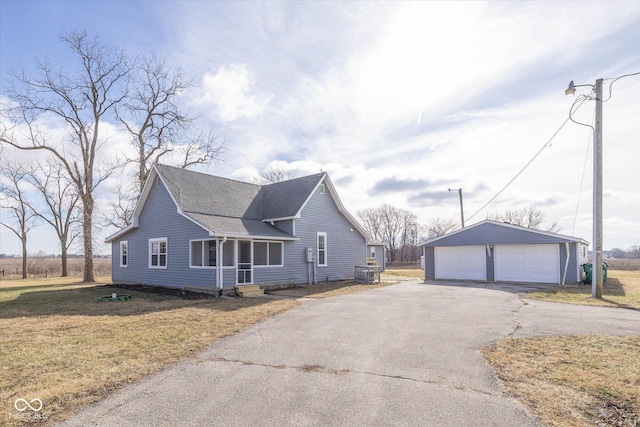 view of front of house featuring a garage, an outdoor structure, and a front lawn