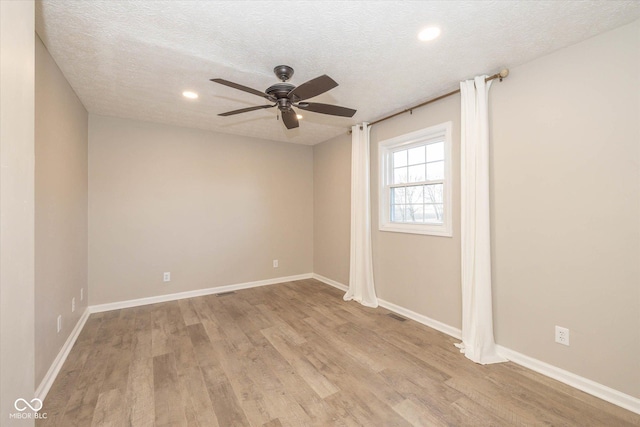 empty room featuring ceiling fan, a textured ceiling, and light wood-type flooring