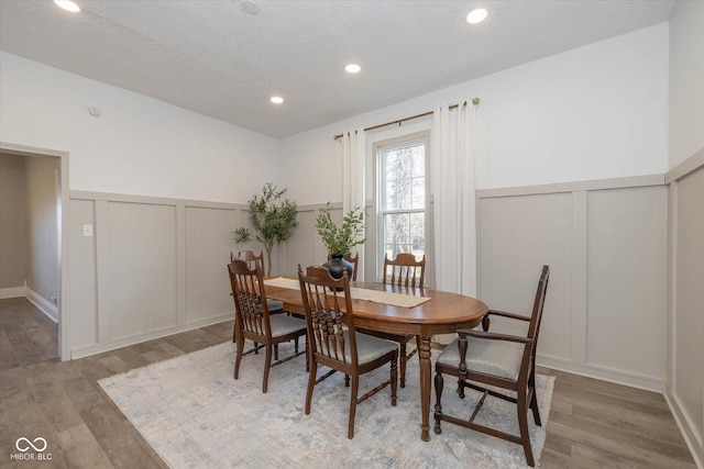 dining room with hardwood / wood-style floors and a textured ceiling