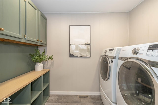 washroom featuring cabinets and washing machine and clothes dryer