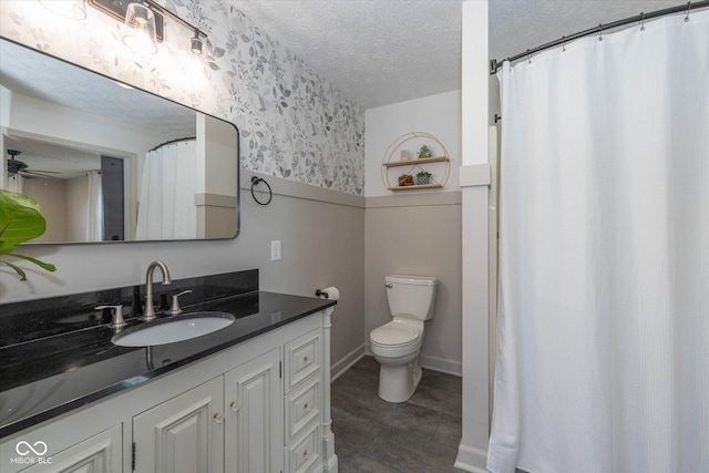 bathroom featuring vanity, toilet, and a textured ceiling