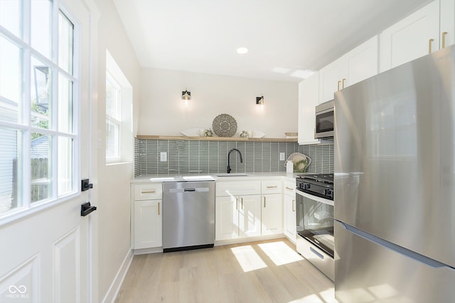 kitchen featuring white cabinetry, sink, tasteful backsplash, and appliances with stainless steel finishes