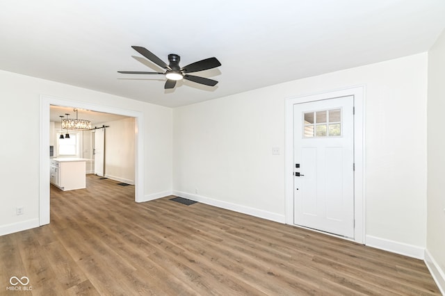 interior space with ceiling fan with notable chandelier and dark wood-type flooring