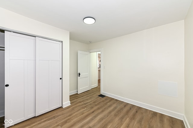 unfurnished bedroom featuring wood-type flooring and a closet