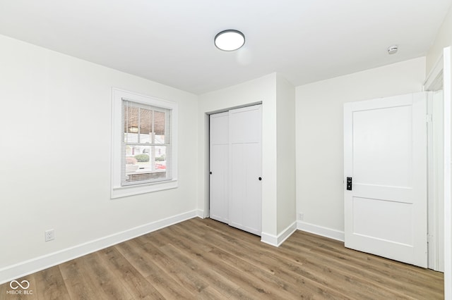 unfurnished bedroom featuring wood-type flooring and a closet