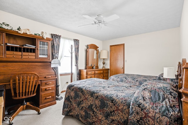 carpeted bedroom featuring ceiling fan and a textured ceiling